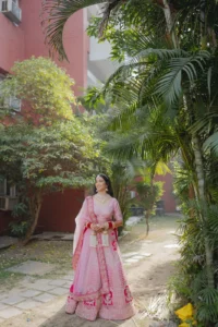 Bride in Pink Lehenga Among Lush Greenery