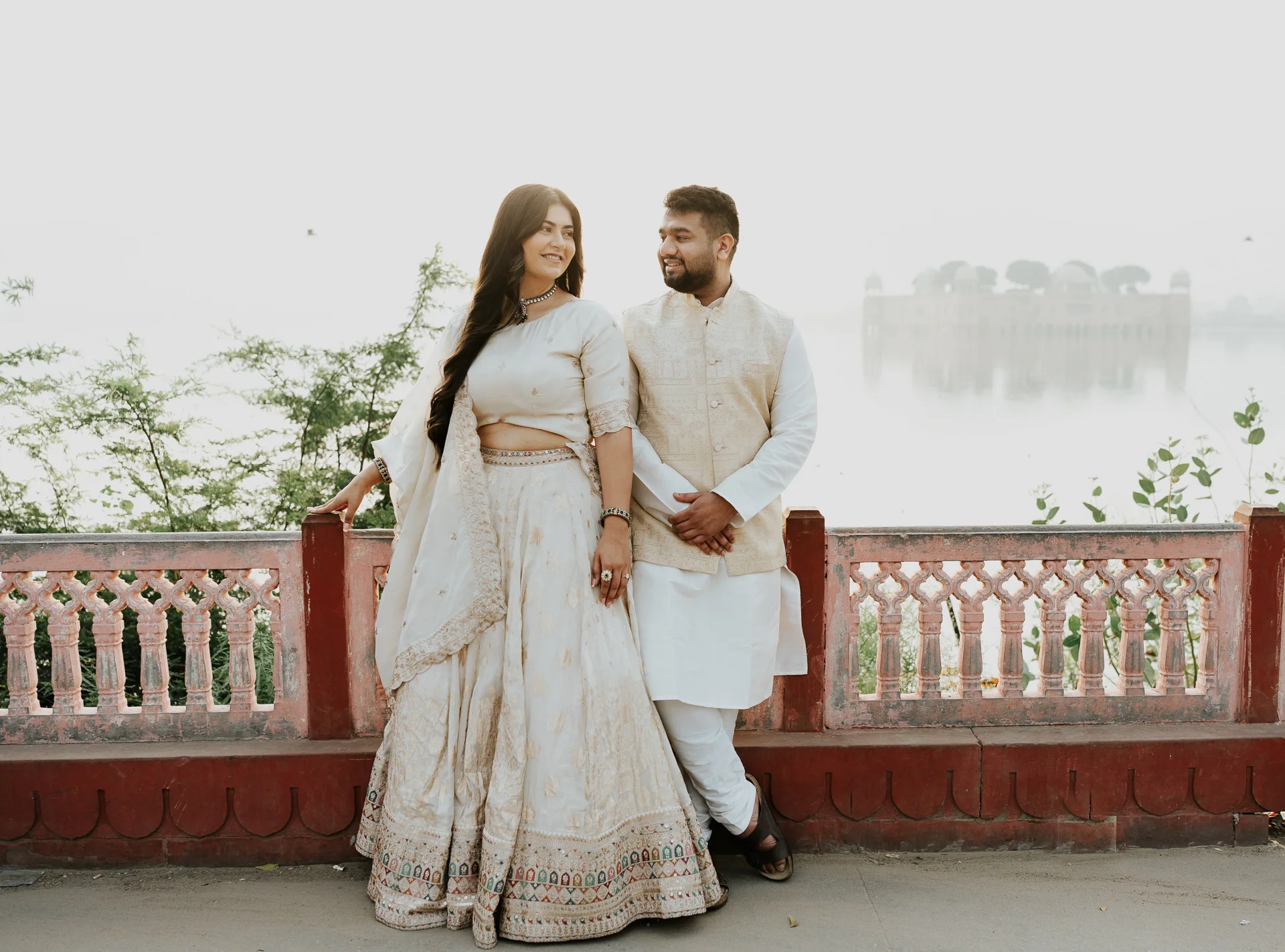 Bride and groom walking along a balcony railing, Jaipur