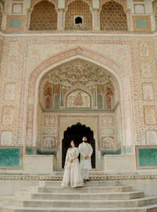 Bride standing alone in a carved sandstone archway, Amer Fort