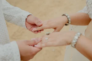 Close-up of couple_s clasped hands with bracelet