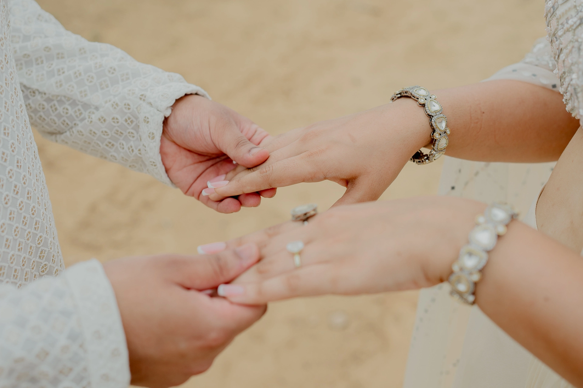 Close-up of couple_s clasped hands with bracelet