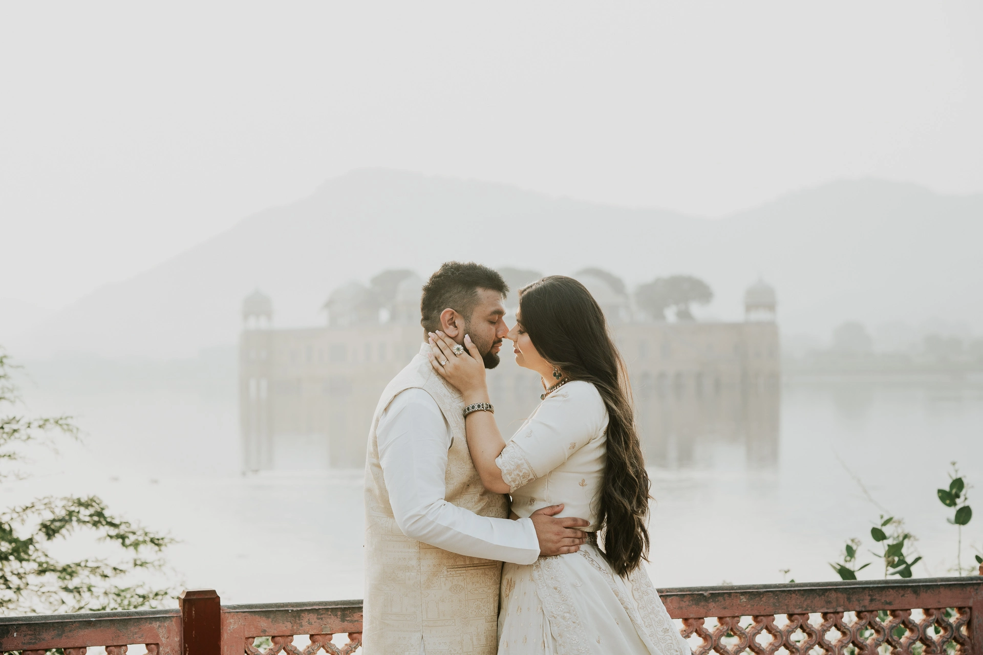 Couple embracing with a lake and hills behind them