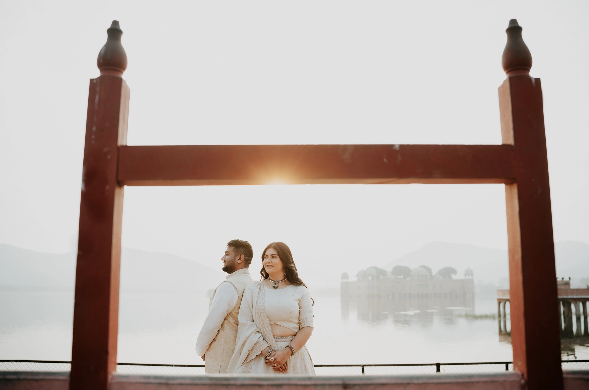 Couple framed under a wooden swing structure with lake view, Jaipur