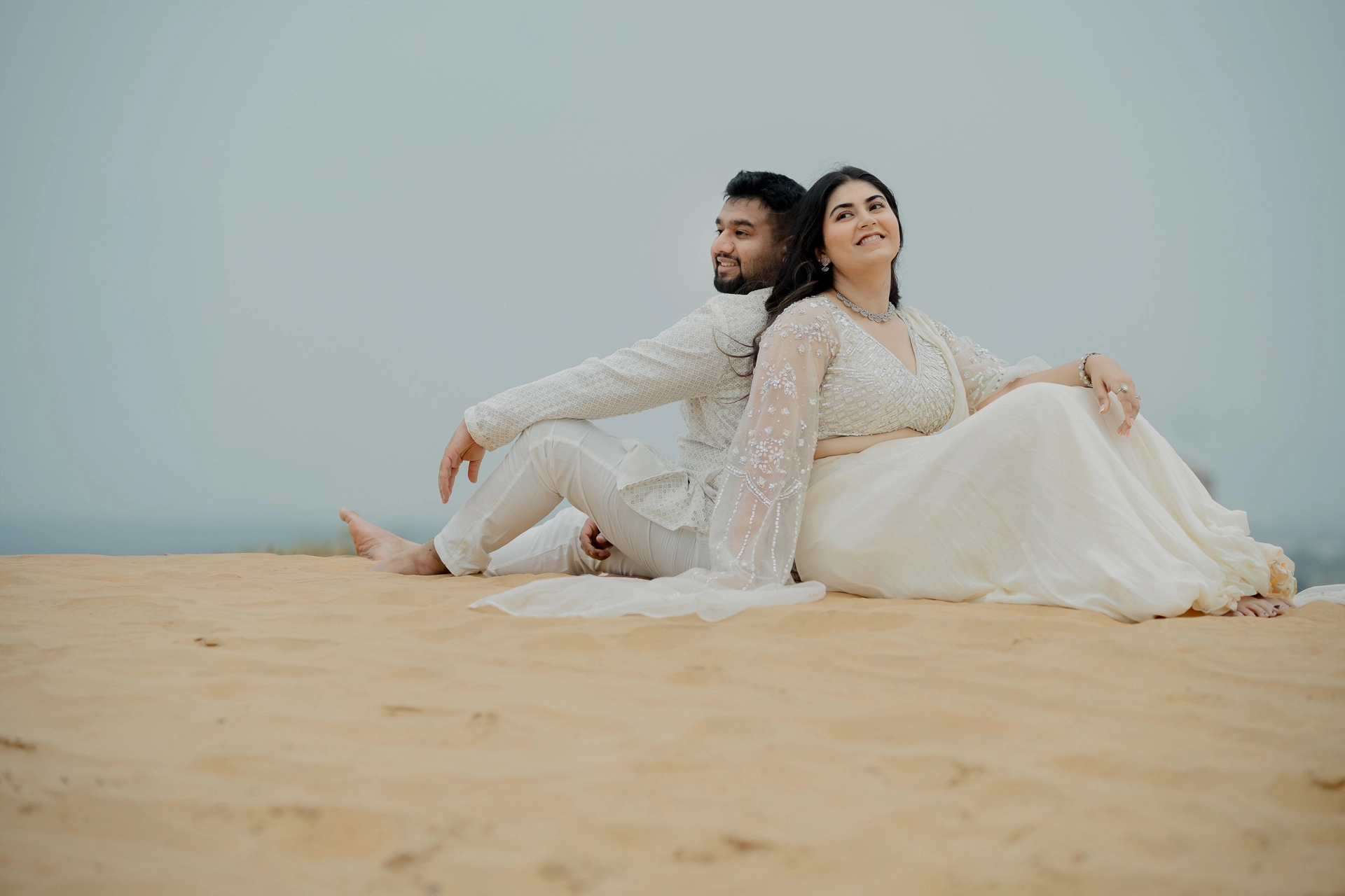 Couple sitting close together on sand