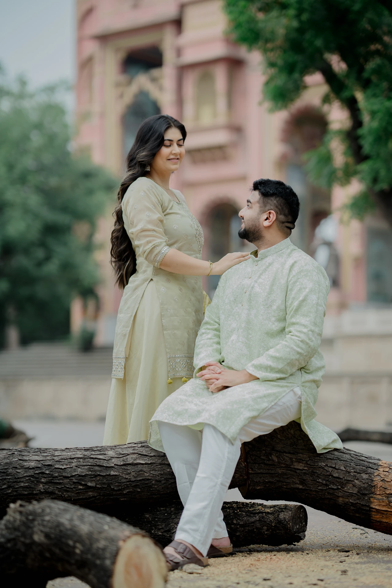 Couple sitting together near a stone pillar, Jaipur pre-wedding shoot