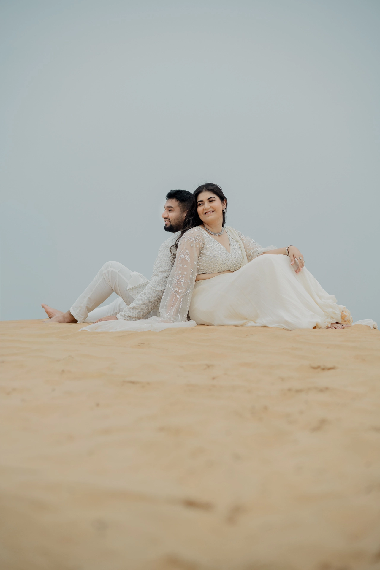 Couple sitting together on a sand dune