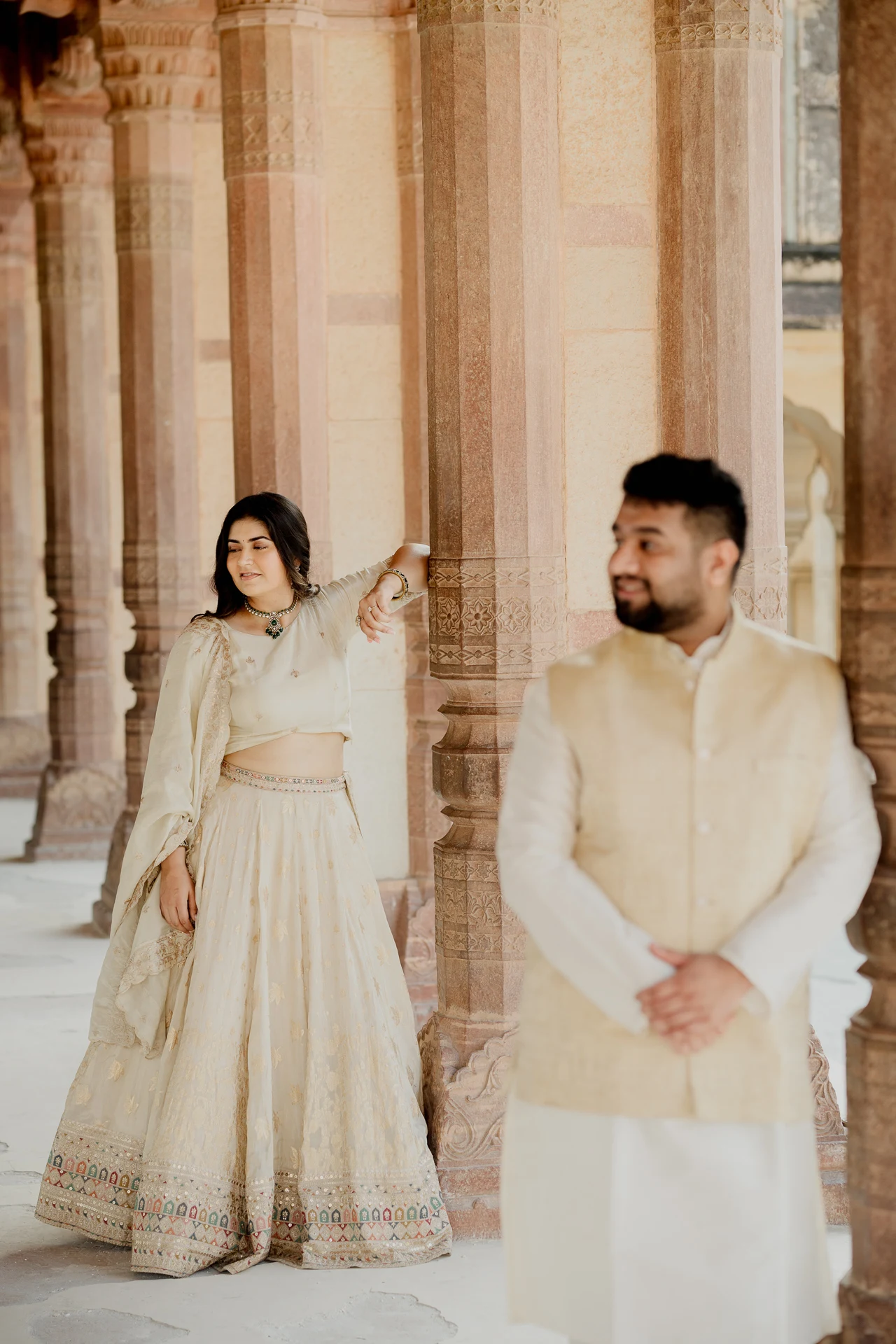 Couple standing among carved stone columns, Amer Fort