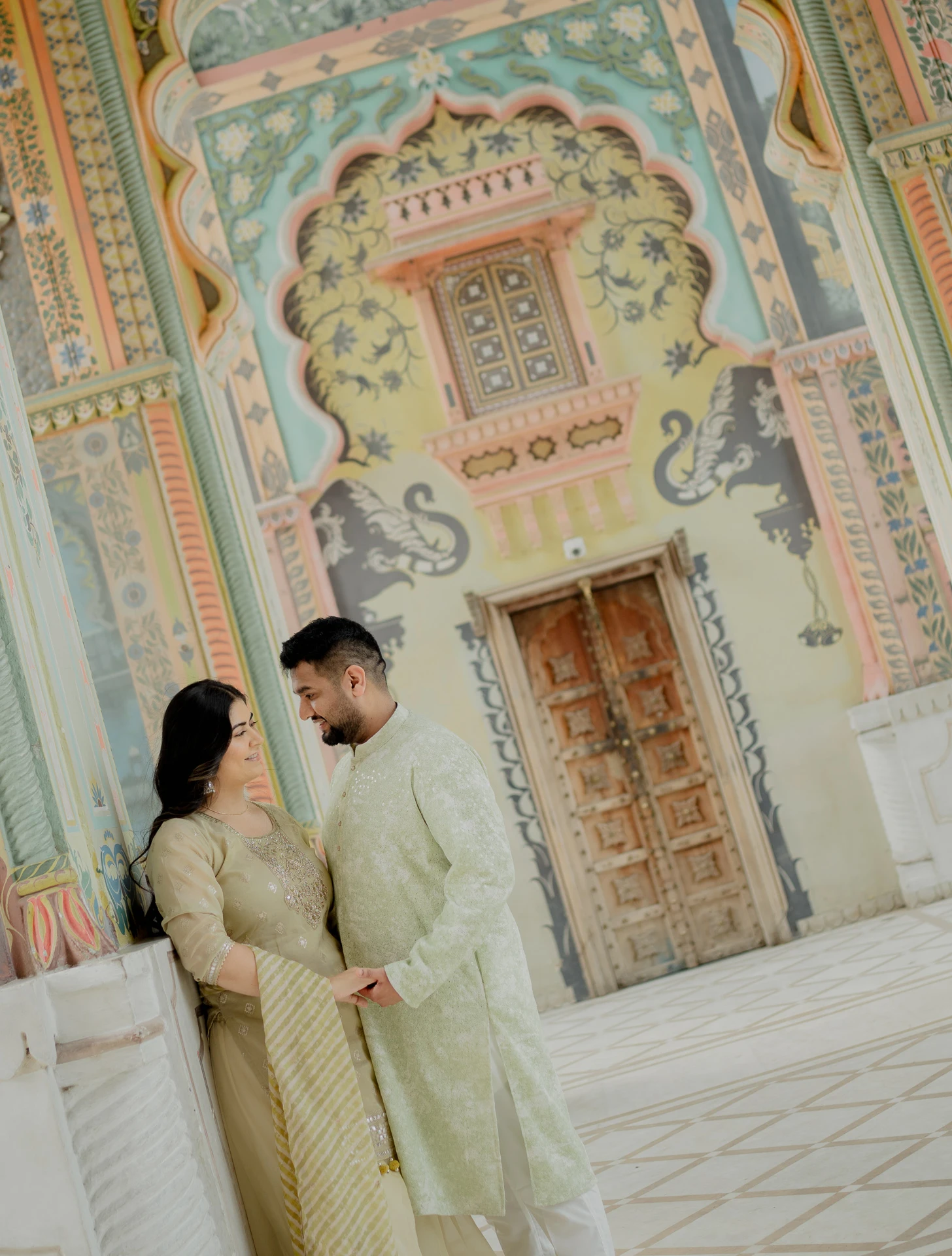 Couple standing beneath a decorative arch, Jaipur pre-wedding shoot