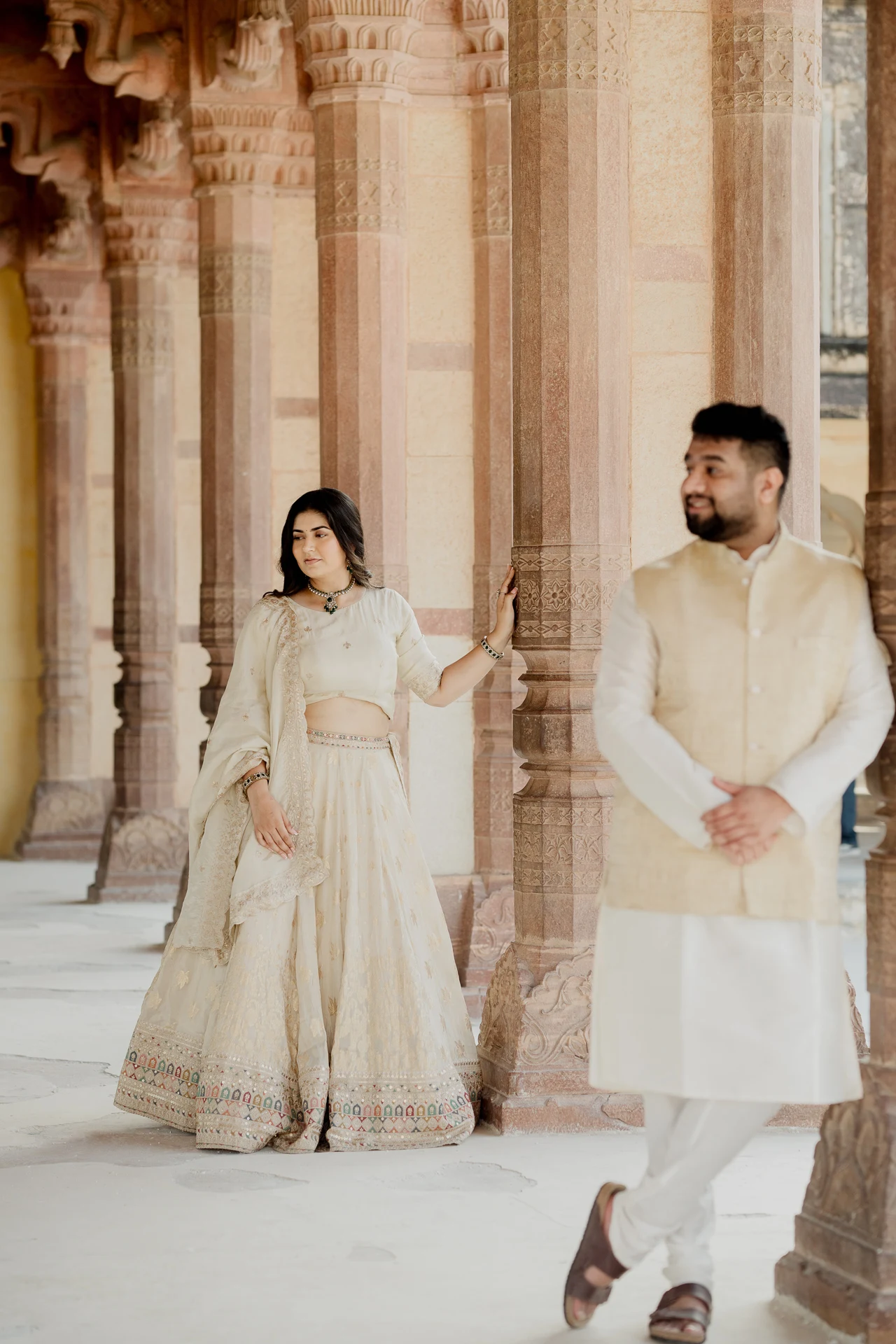 Couple standing between sandstone pillars, Amer Fort