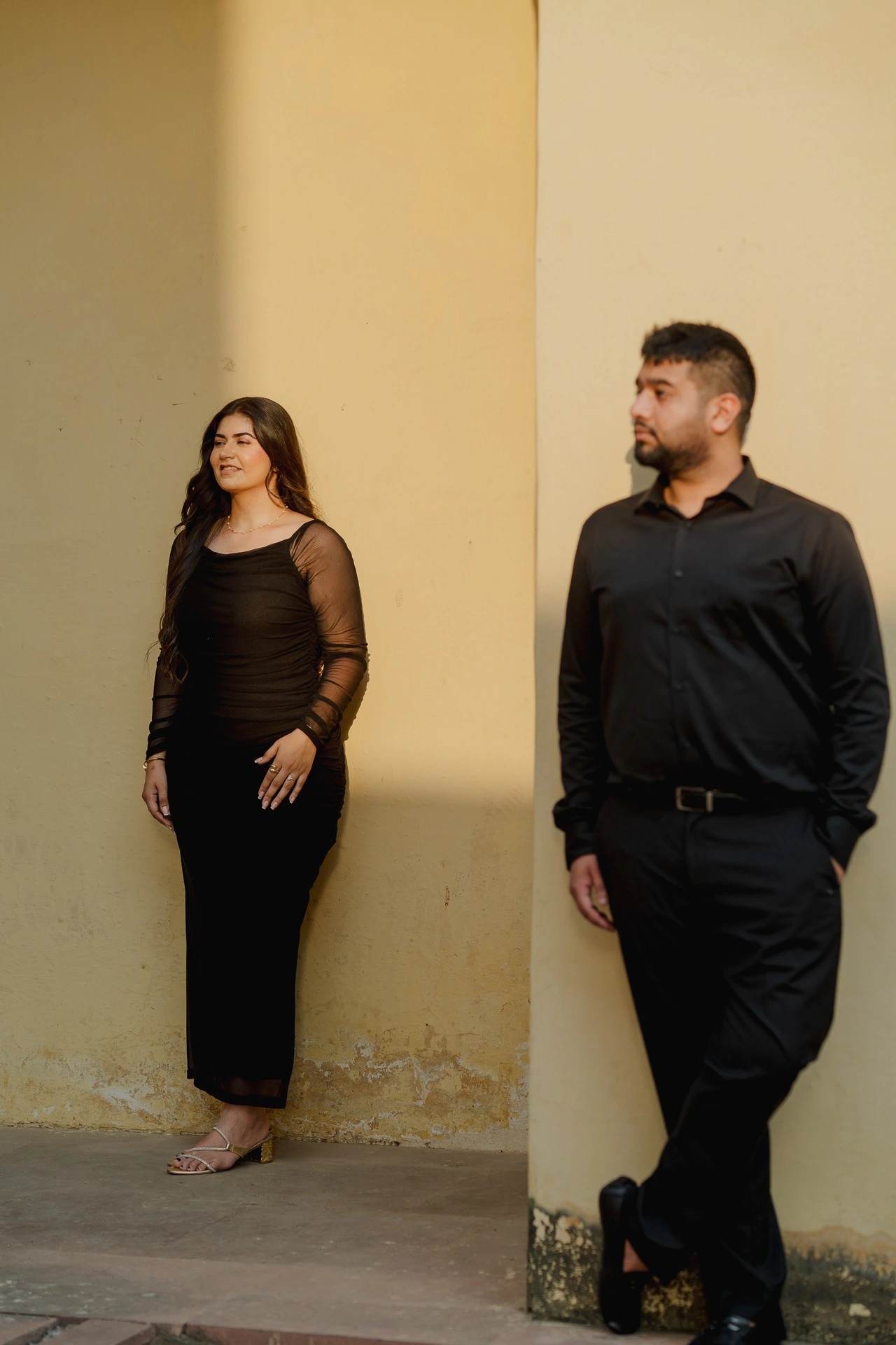 Couple standing close together beside a sundial structure