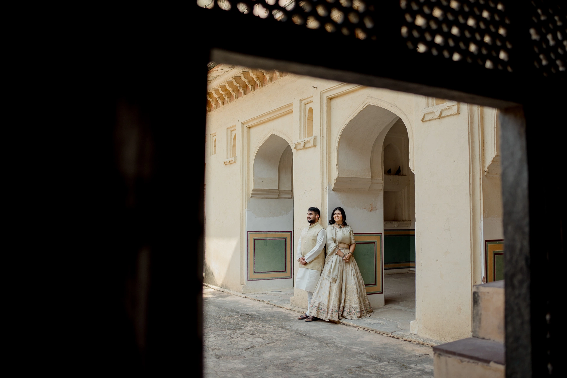 Couple standing in a dark archway with fairy lights, Amer Fort