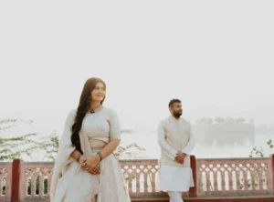 Couple standing on a balcony with misty hills in the distance