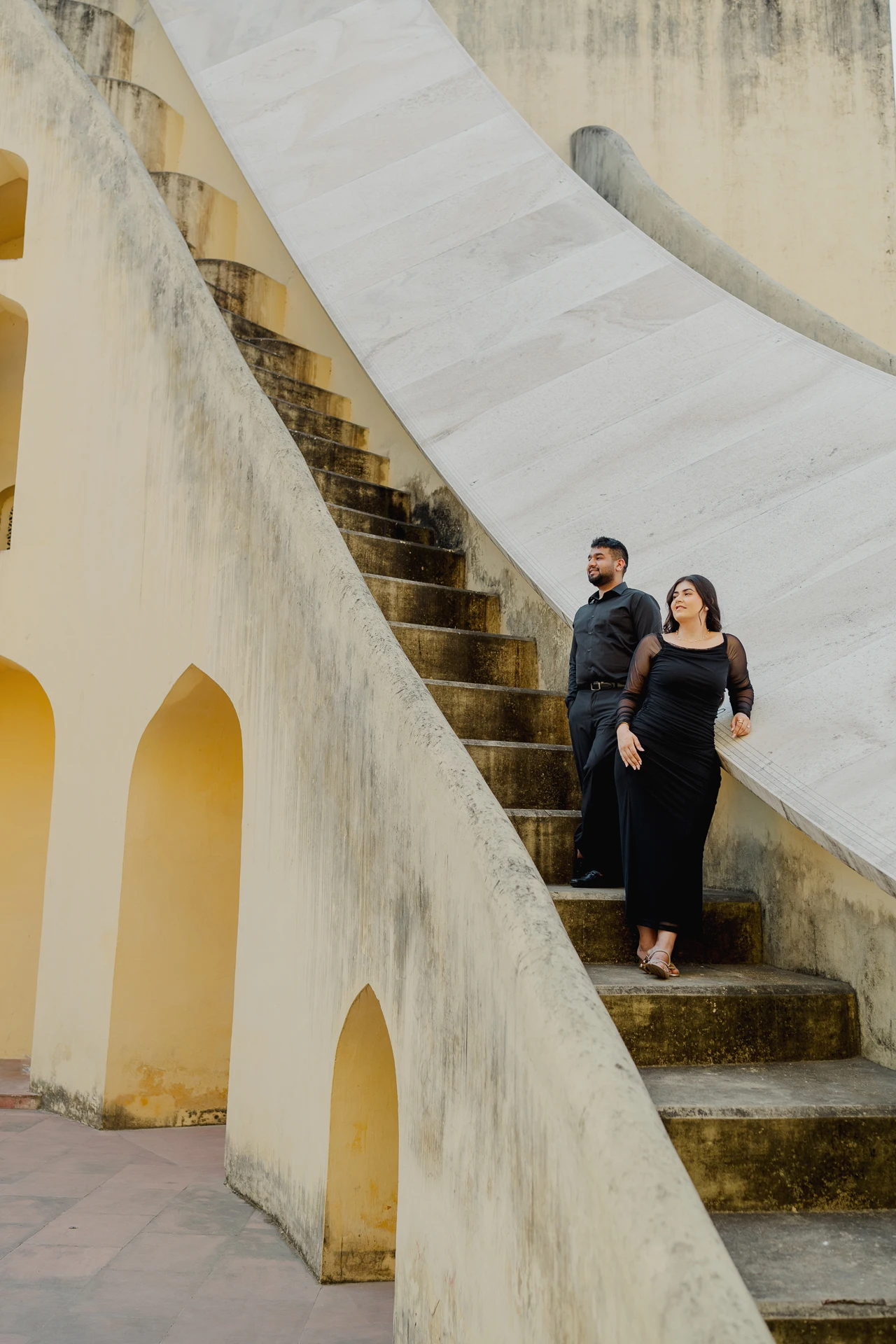 Couple standing on a curved stone stairway