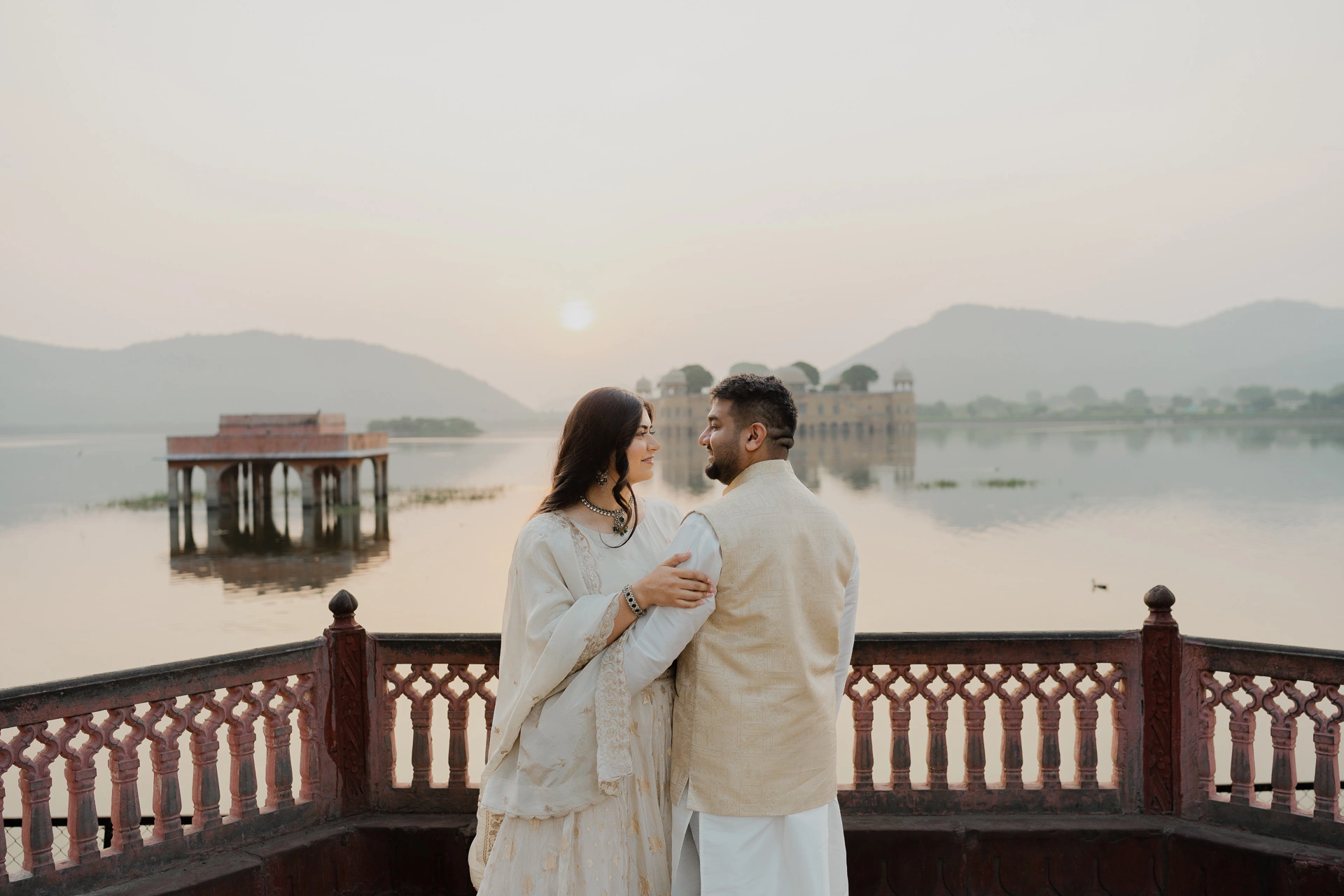 Couple standing on a terrace overlooking a lake, Jaipur pre-wedding shoot