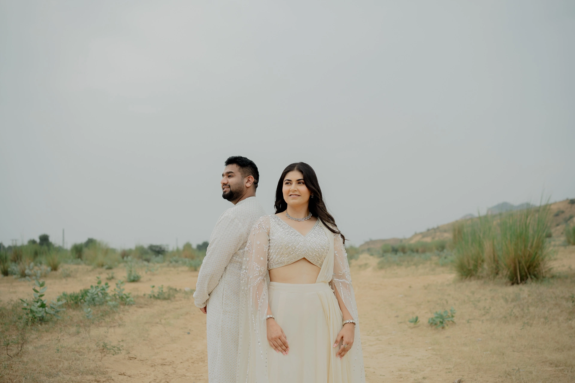 Couple standing side by side in an open landscape
