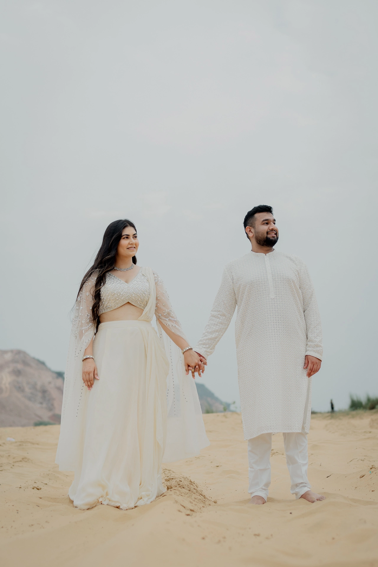 Couple standing together in a sandy open area, Jaipur pre-wedding shoot