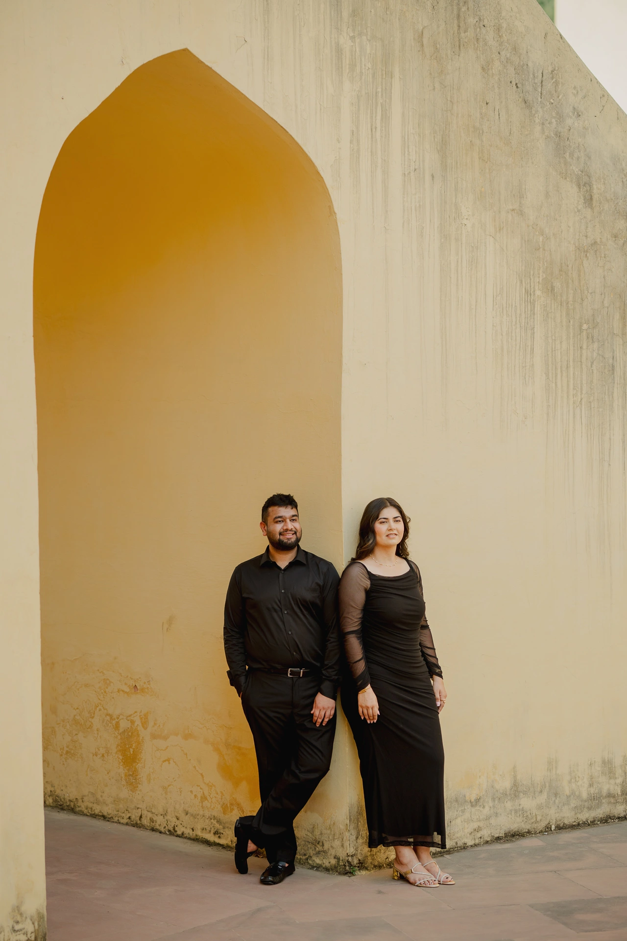 Couple standing under an arch at Jantar Mantar, Jaipur