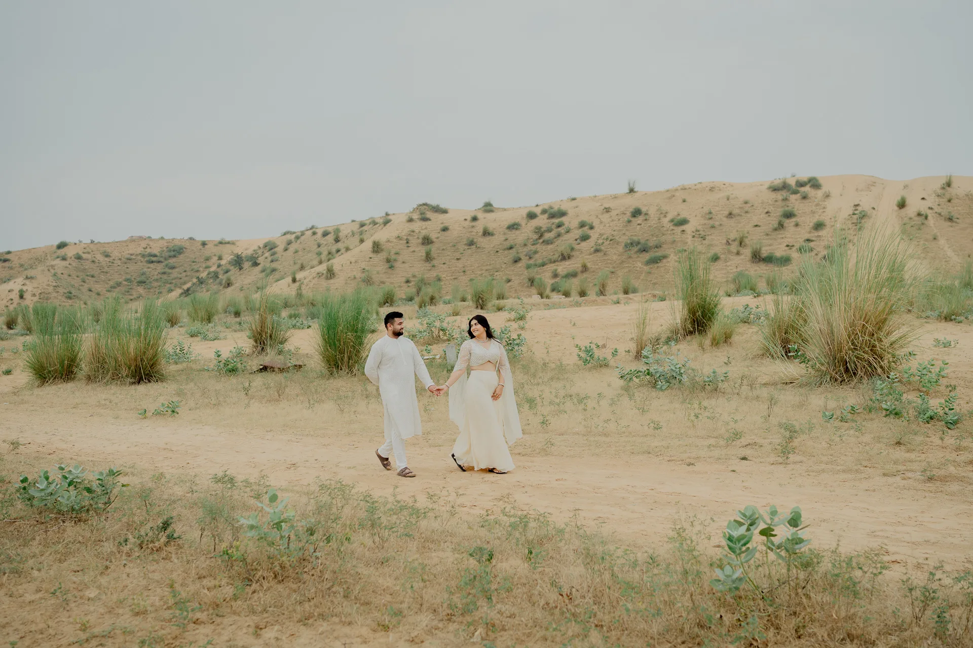Couple walking together in sand dunes, Jaipur pre-wedding shoot