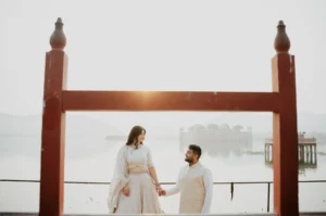Couple walking under a rustic wooden arch by the lake